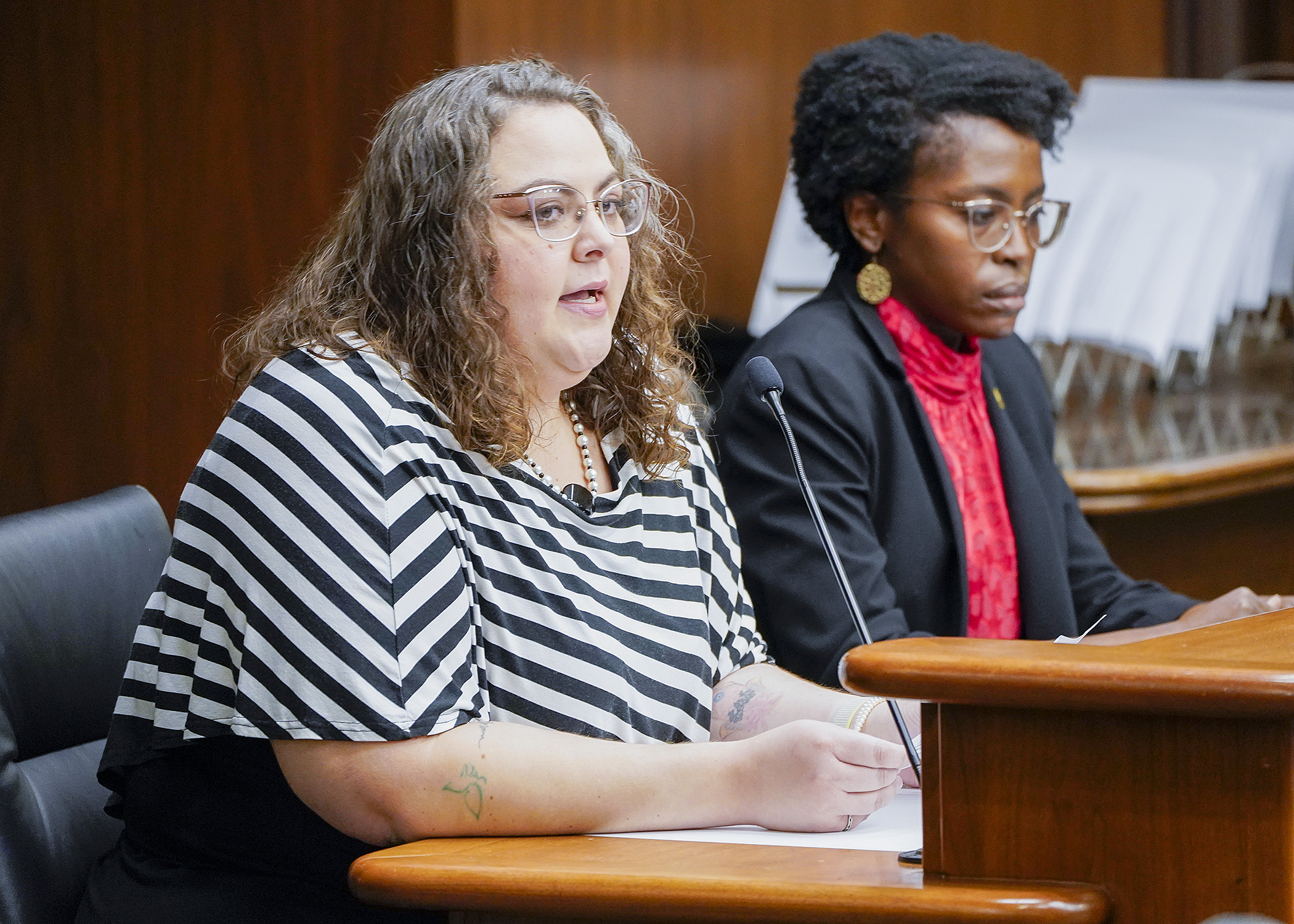 Ivory Taylor, associate director at the Housing Justice Center, testifies before the House Housing Finance and Policy Committee during discussion of HF917, sponsored by Rep. Esther Agbaje, right. (Photo by Andrew VonBank)